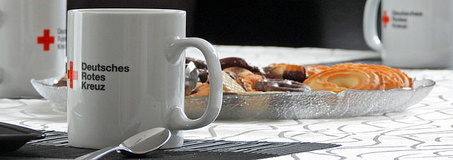 DRK Tassen und ein Tablett mit Keksen auf einem Tisch 